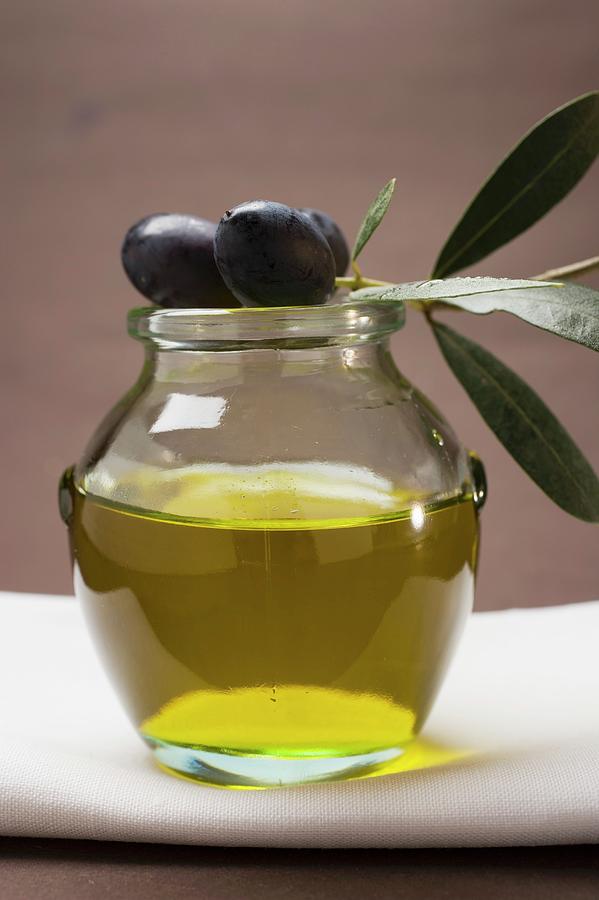 Olive Sprig With Black Olives On Jar Of Olive Oil Photograph By