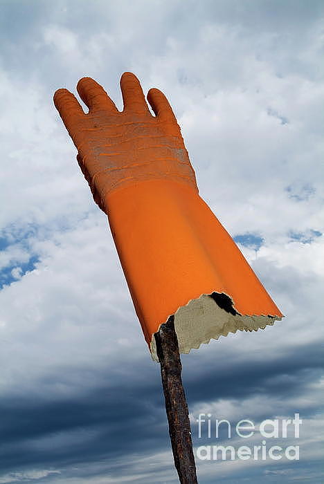 orange-rubber-glove-on-a-wooden-post-against-a-cloudy-sky-sami-sarkis.jpg