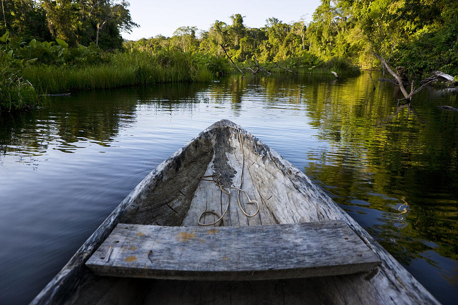 The Front Of A Dugout Canoe In Calm by Mattias Klum