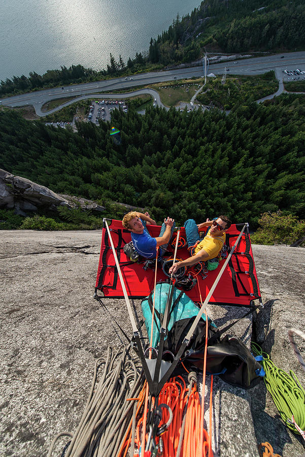 Top View Of Two Men Looking Up And Sitting On Portaledge At Sunset