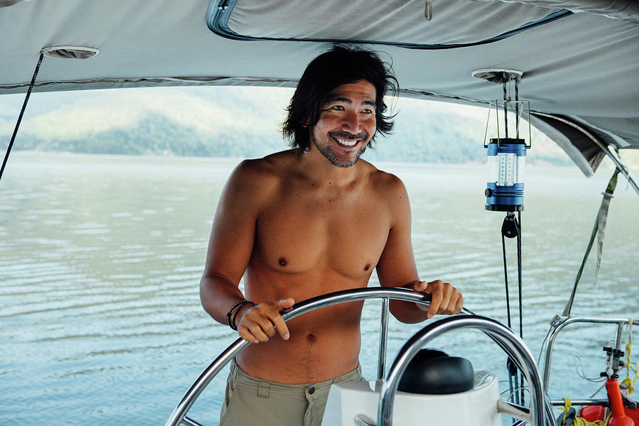 Happy Shirtless Man Looking Away While Sailing Boat On Sea Photograph By Cavan Images