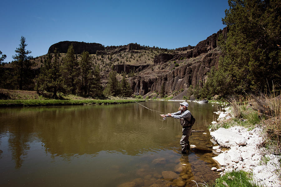 Side View Of Mature Man Fishing In River By Mountain Photograph By