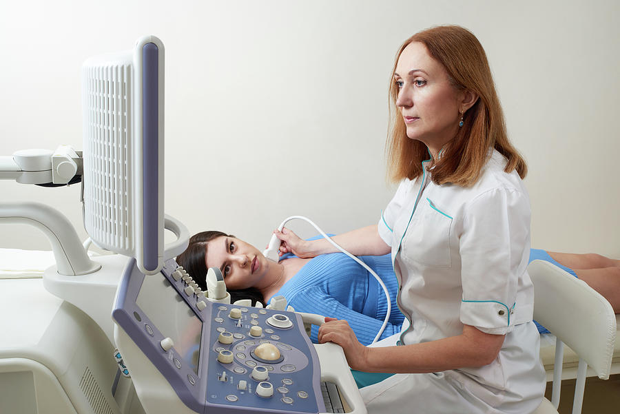 Doctor Using Ultrasound Scanning Machine Examining Female Neck 1