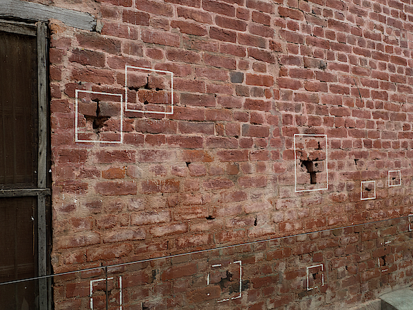 bullet holes in brick wall