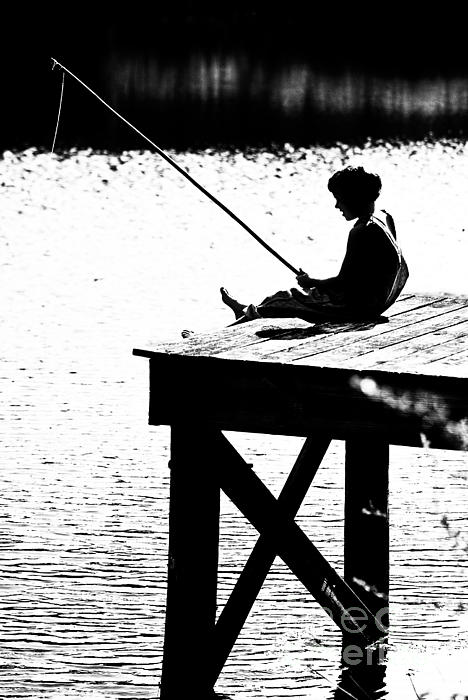 Silhouette of a Boy fishing from a dock on lake or pond. Ornament