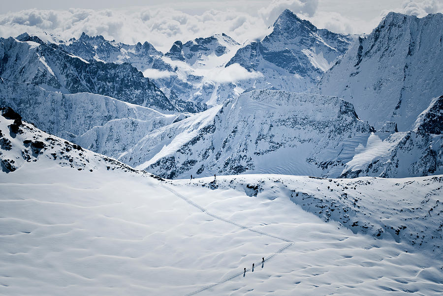 Nature Photograph - A Group Of Skiers Climb Toward The Col #1 by Jeff Diener