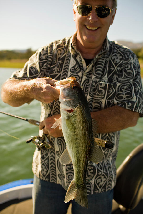 Fish Photograph - A Man Holds Up His Catch Proudly #1 by Jay Reilly