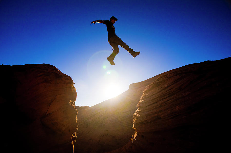 A Man Jumps Across A Chasm While Hiking Photograph by Kirk Mastin ...