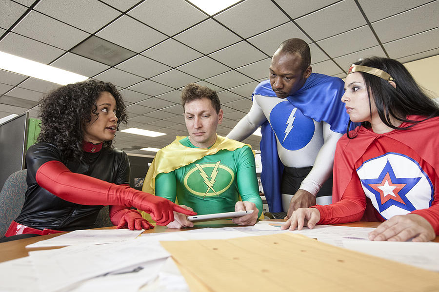 A mixed race team of office super heros in their office. #1 Photograph by Mint Images