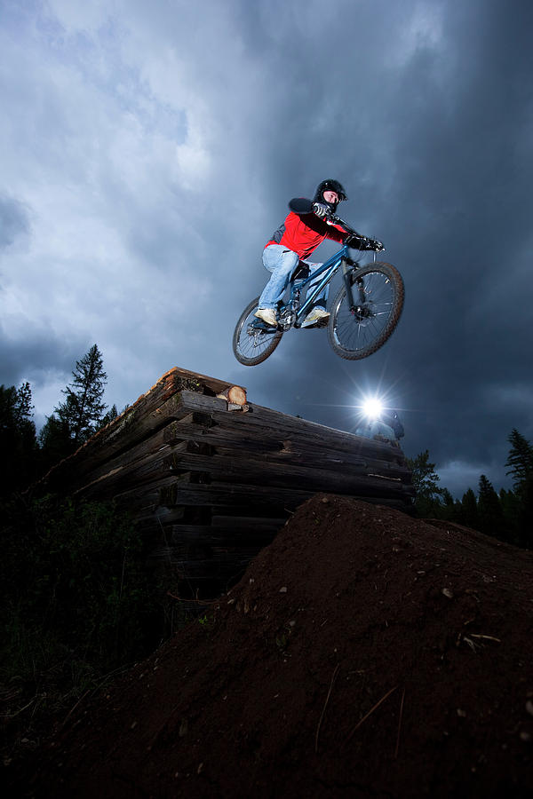 Bicycle Photograph - A Mountain Biker Jumps Off A Log Cabin #1 by Patrick Orton