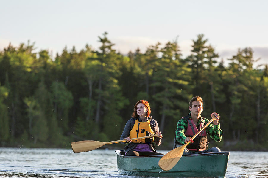 A Young Couple Paddles A Canoe On Long Photograph by Jerry Monkman ...