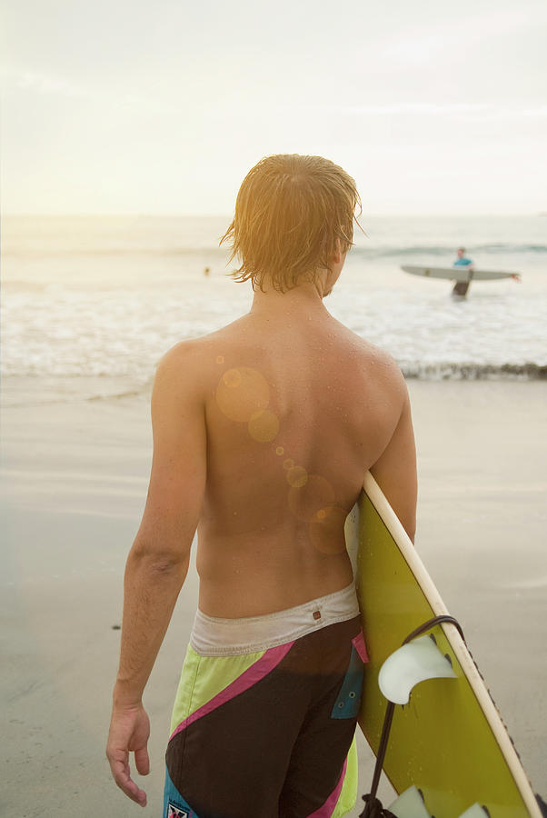 Beach Photograph - A Young Man Holds A Surfboard #1 by Lacey Ann Johnson