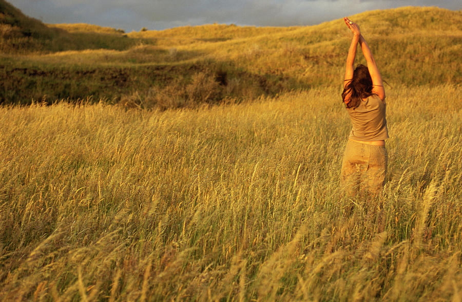Sunset Photograph - A Young Woman Stretches In A Field #1 by Kyle George