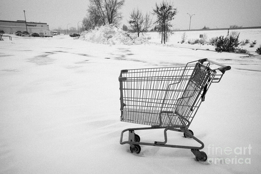 Winter Photograph - abandoned shopping cart in snow covered supermarket parking lot Saskatoon Saskatchewan Canada #1 by Joe Fox