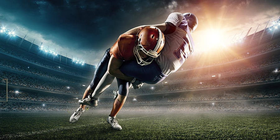 American football player being tackled #1 Photograph by Dmytro Aksonov