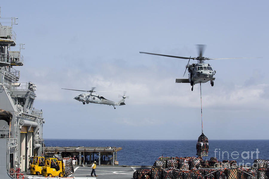 Transportation Photograph - An Mh-60s Sea Hawk Picks Up Cargo #1 by Stocktrek Images