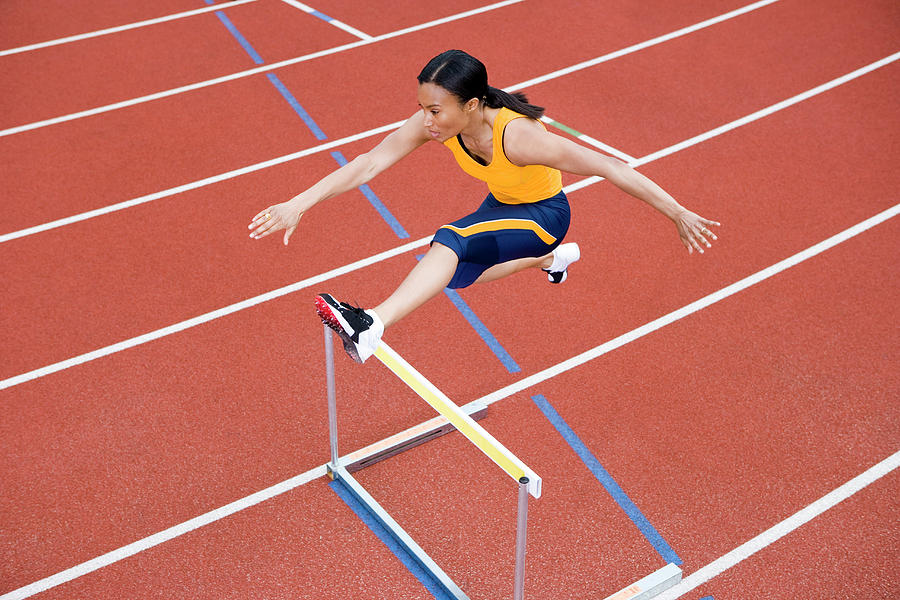 Athlete Jumping Over A Hurdle #1 Photograph by Gustoimages/science Photo Library