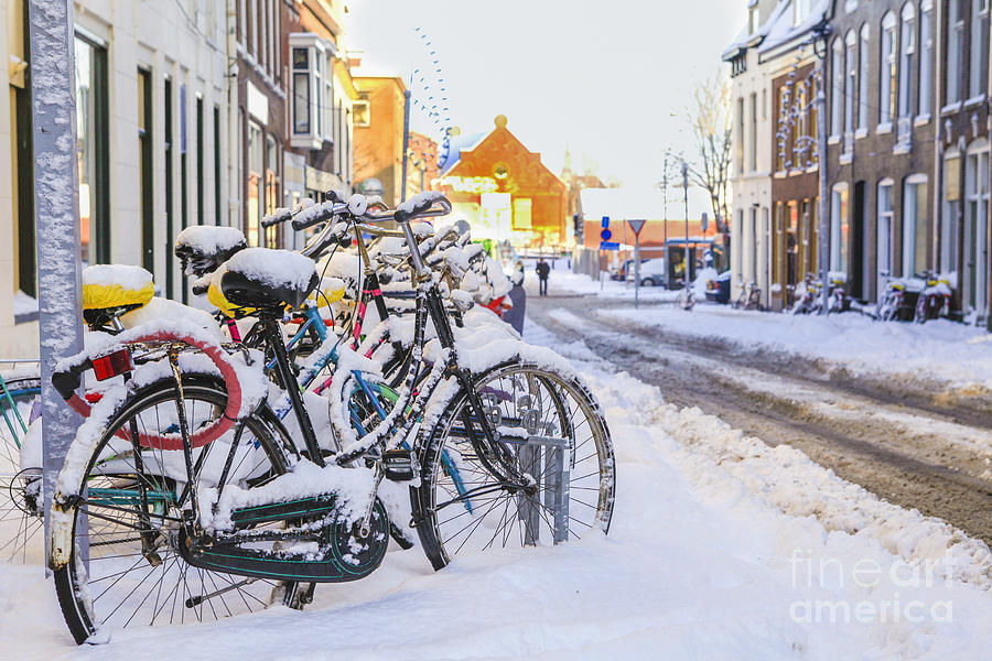 Bicycles in the snow on a  street Photograph by Patricia Hofmeester