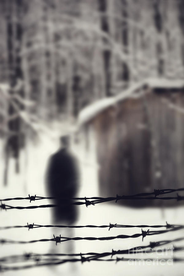 Blurred figure behind barbed wire fence #1 Photograph by Sandra Cunningham