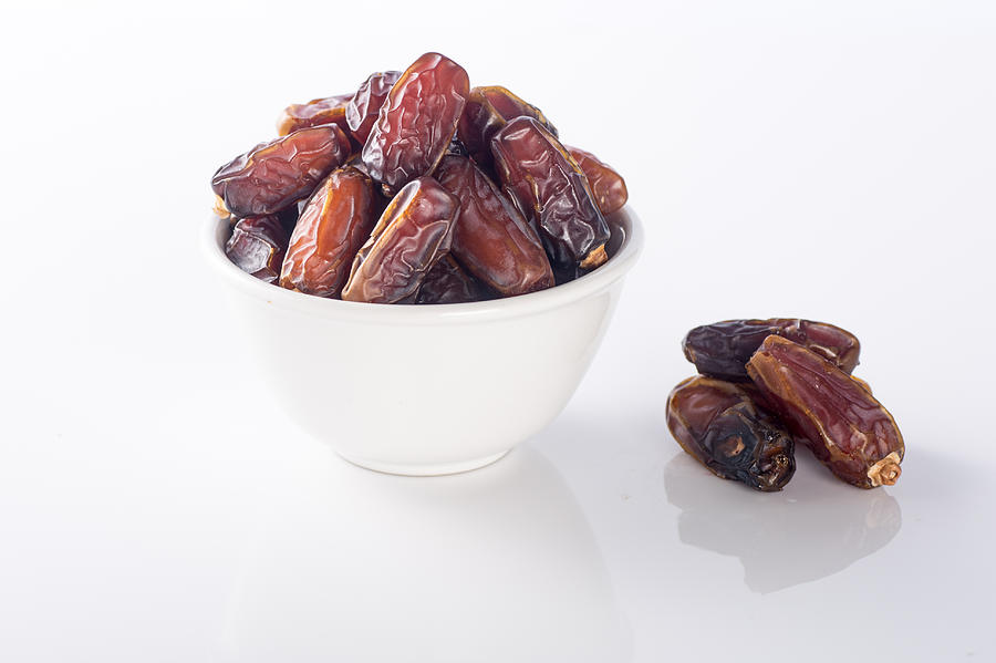 Bowl of dried dates isolated on white background #1 Photograph by Azri Suratmin