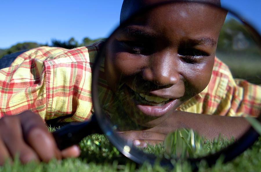 Boy Using A Magnifying Glass Photograph by Ian Hooton/science Photo Library