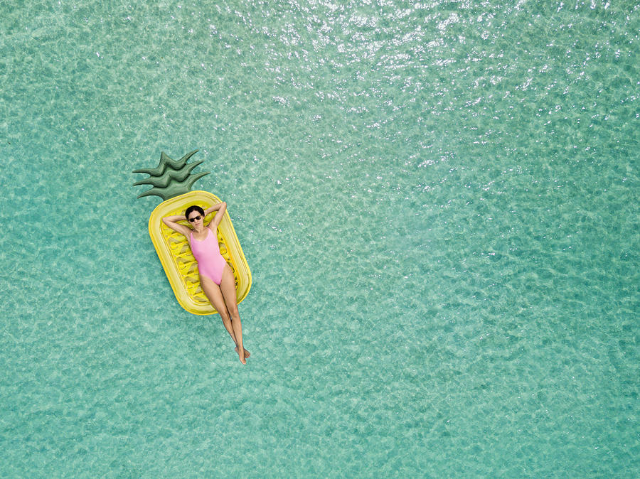 Carefree woman on inflatable pineapple #1 Photograph by Orbon Alija