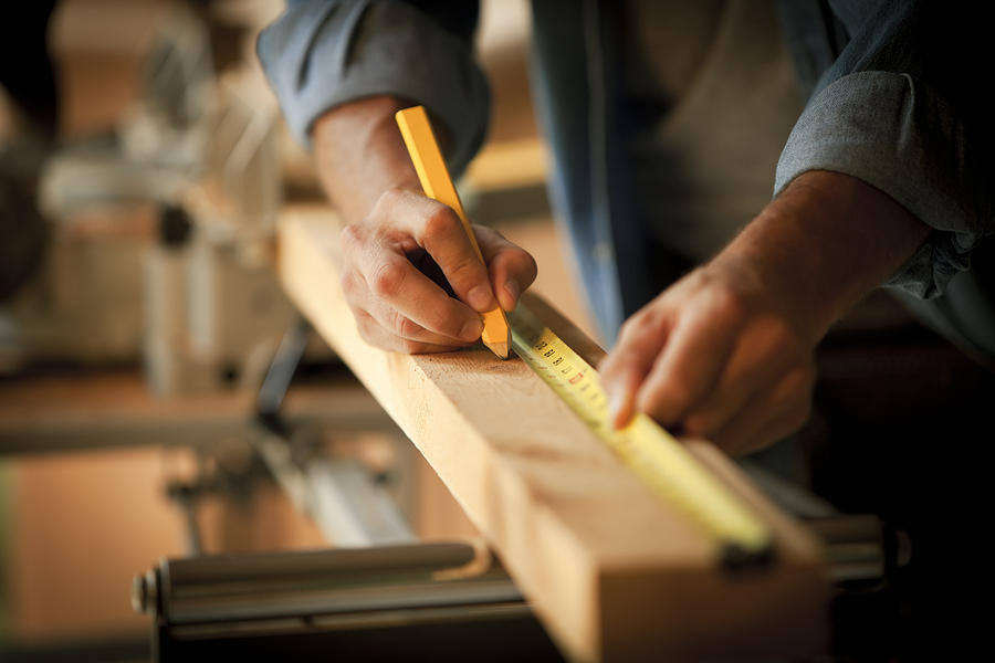 Carpenter Measuring a Wooden Plank Photograph by Stevecoleimages