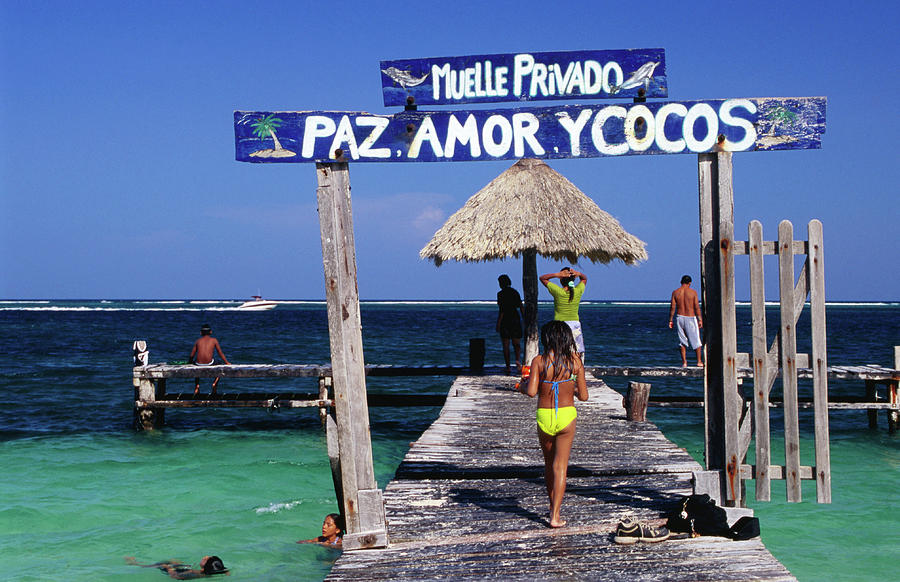 Children Play On Jetty Pas Amor Y Cocos #1 Photograph by Dallas Stribley
