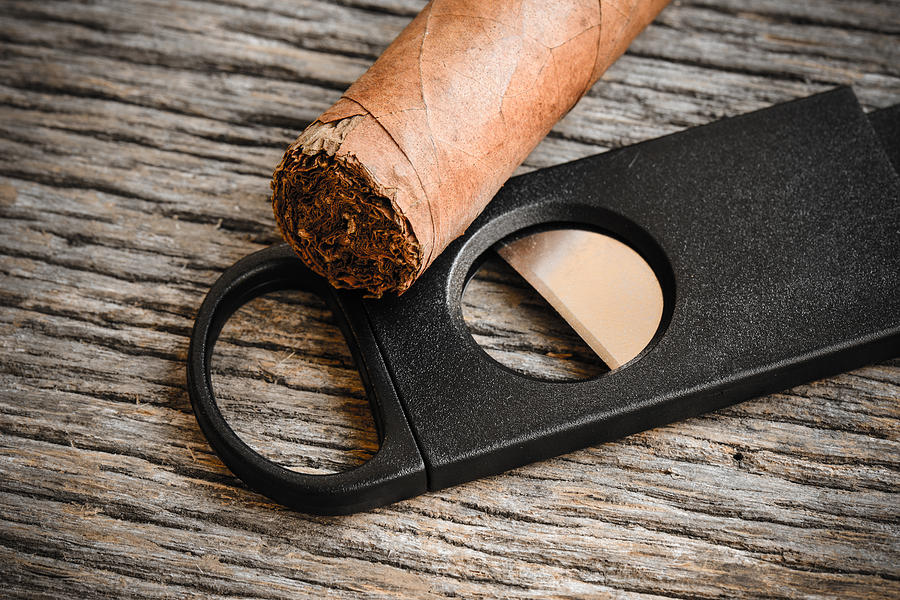 Cigar and Cigar Cutter on Rustic Wood Background #1 Photograph by Brandon Bourdages