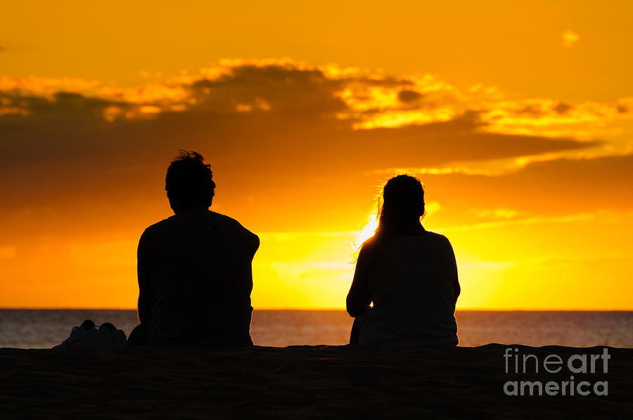 Couple watching the sunset on a beach in Maui Hawaii USA #1 Photograph by Don Landwehrle
