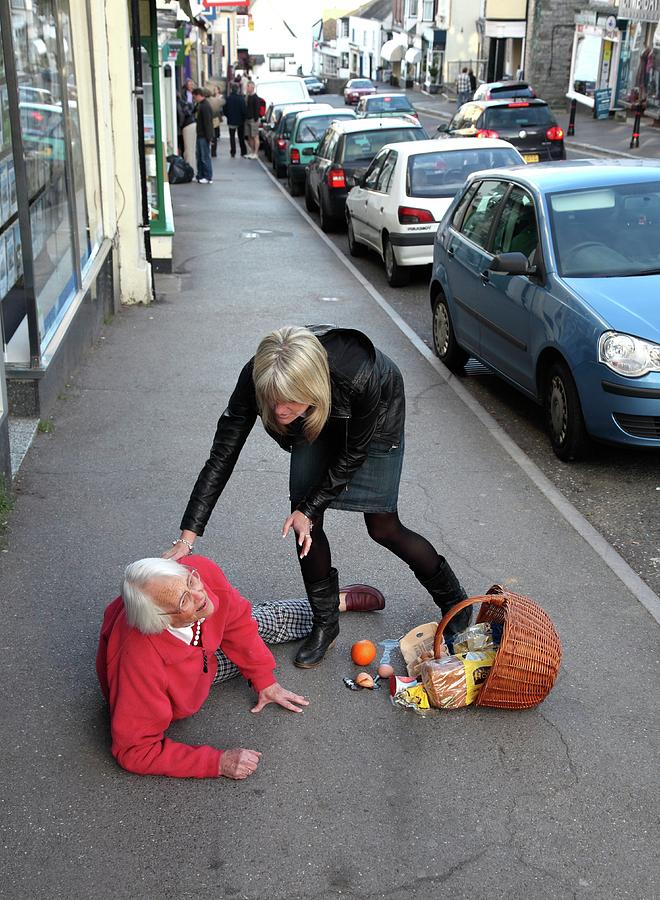 Elderly Woman Being Helped After Falling #1 Photograph by Mark Thomas/science Photo Library