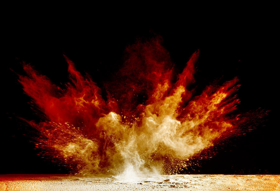 Explosion by an impact of a cloud of particles of powder of color red and yellow on a black background. #1 Photograph by Jose A. Bernat Bacete