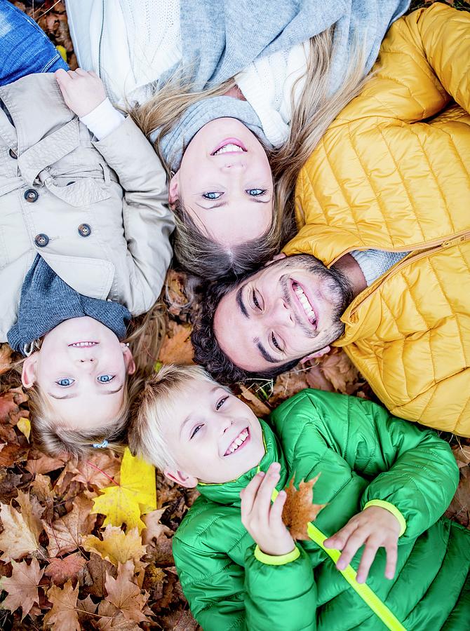 Family Lying On Dried Leaves #1 Photograph by Science Photo Library