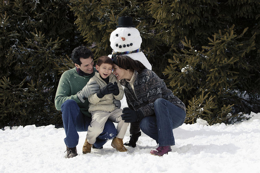 Family with snowman #1 Photograph by Comstock Images