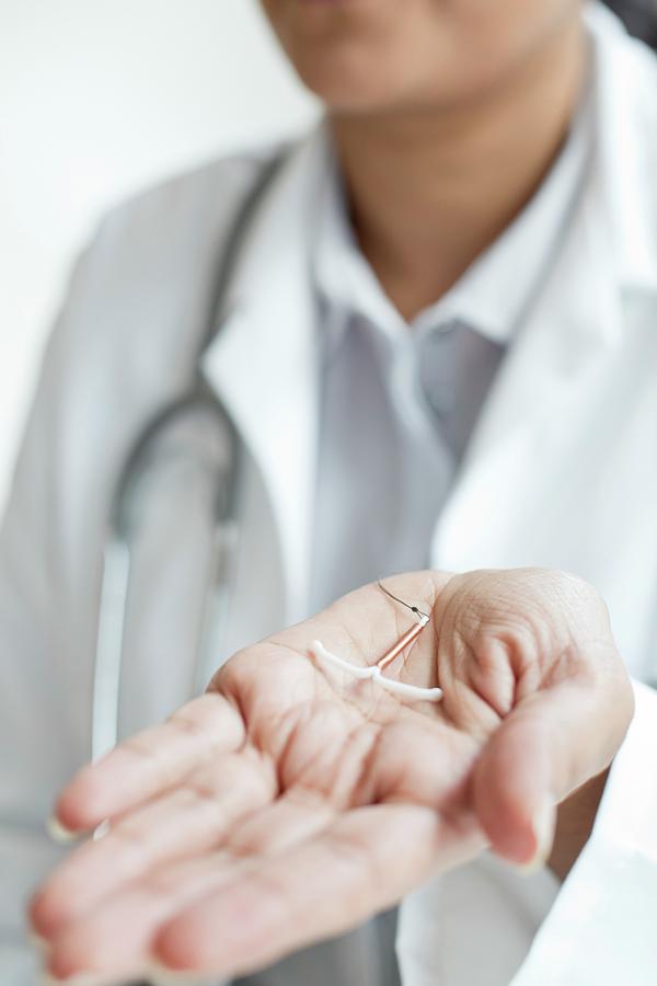 Female Doctor Holding An Iud Photograph By Science Photo Library