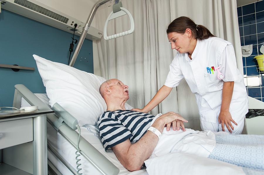 Female Nurse With Hand On Patients Shoulder Photograph By Arno Massee