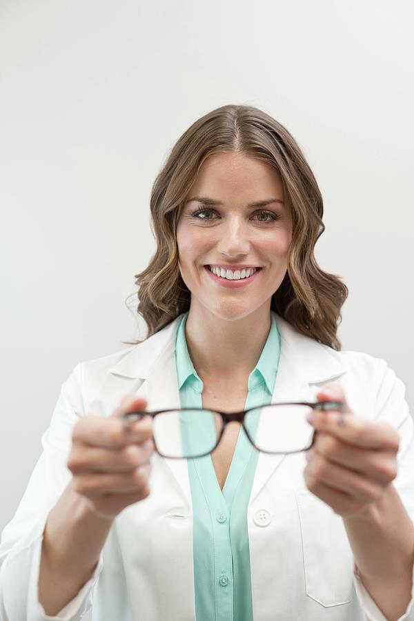 Female Optician Holding Glasses #1 Photograph by Science Photo Library