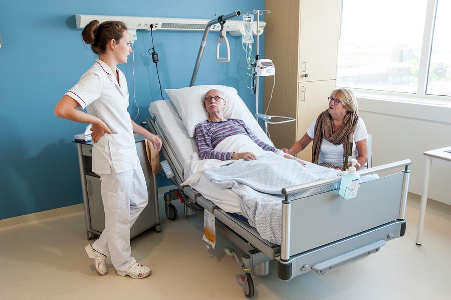 Female Visitor And Nurse Talking To Senior Man Photograph By Arno