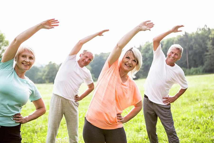 Four People In Field Exercising Photograph by Science Photo Library ...