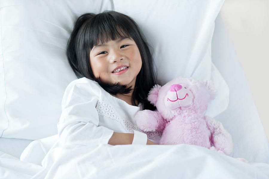 Asian Ethnicity Photograph - Girl In Hospital Bed With Teddy Bear #1 by Science Photo Library