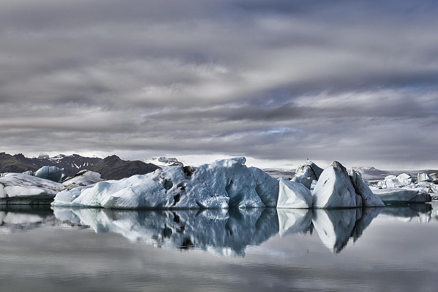 Icebergs floating  in the Jokulsalon glacier lagoon in Iceland #1 Photograph by Sjo