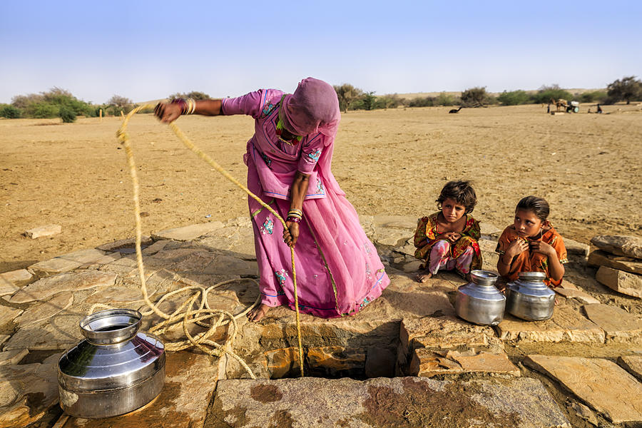 Indian woman drawing water from the well, desert, Rajasthan #1 Photograph by Hadynyah