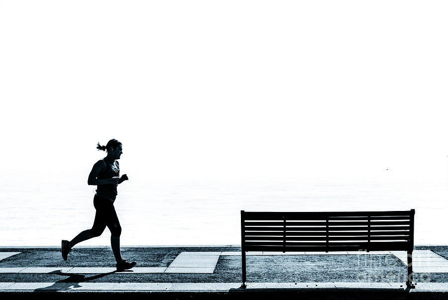 Jogging on the prom. #1 Photograph by Peter Noyce