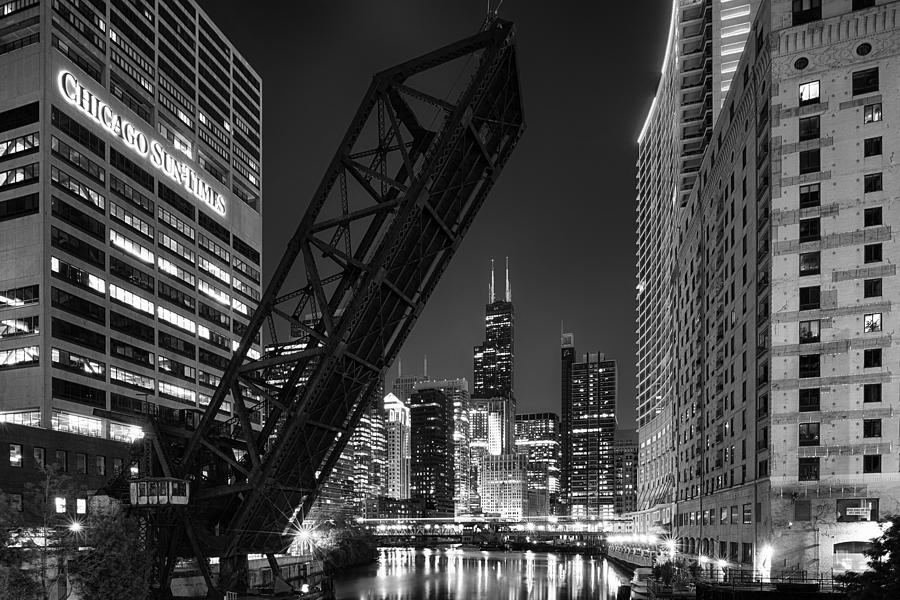 Kinzie Street railroad bridge at night in Black and White Photograph by Sebastian Musial