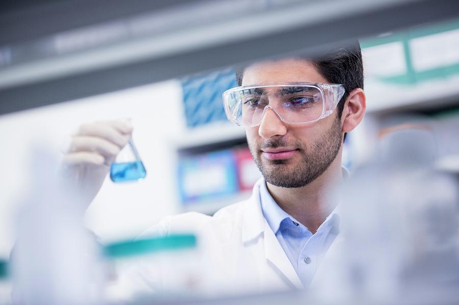 Lab Assistant Looking At Flask Photograph By Science Photo Library 