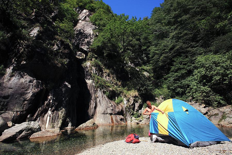 Man Erecting A Tent By A River #1 Photograph by Mauro Fermariello/science Photo Library