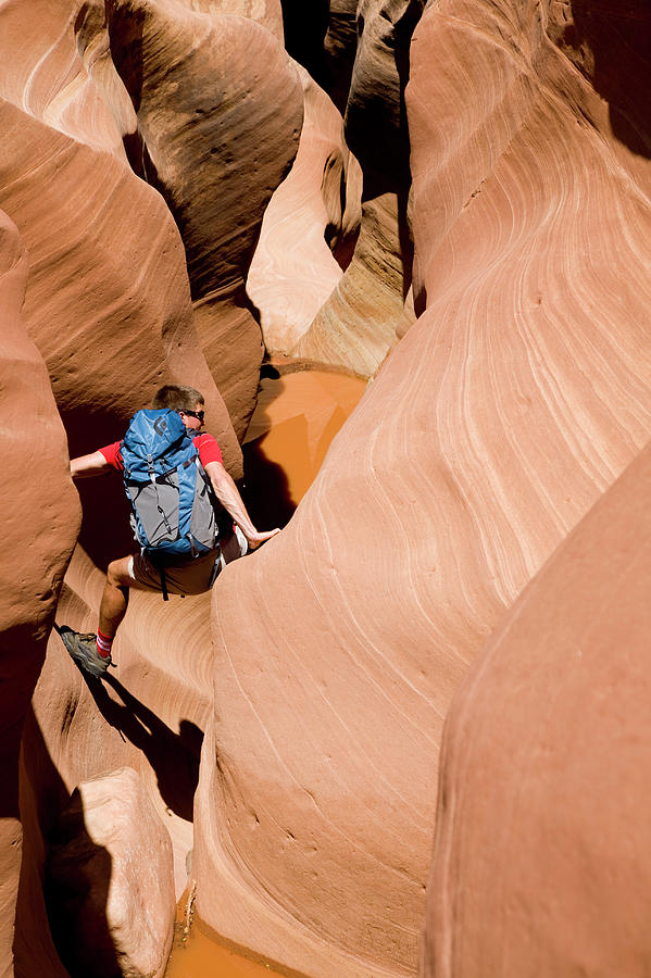 Desert Photograph - Man Hiking Through A Desert Slot Canyon #1 by Adam Clark
