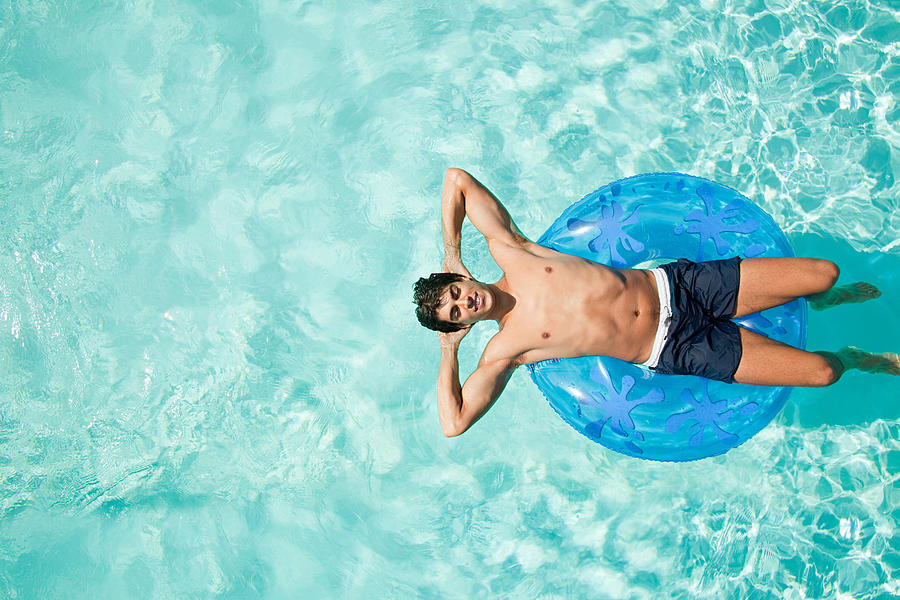 Man on inflatable ring in pool #1 Photograph by Image Source