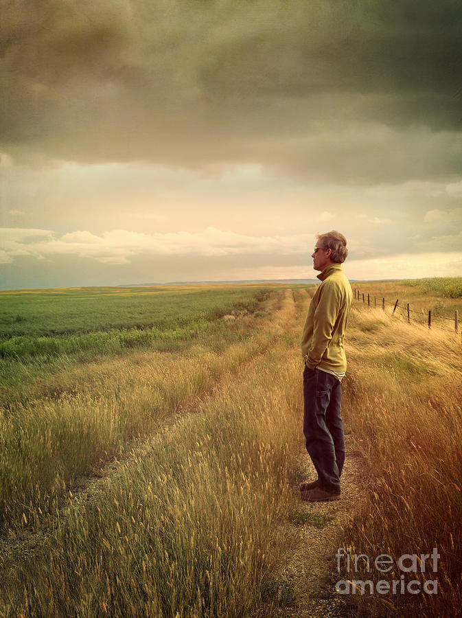 Man standing on Prairie looking out towards sky #1 Photograph by Sandra Cunningham