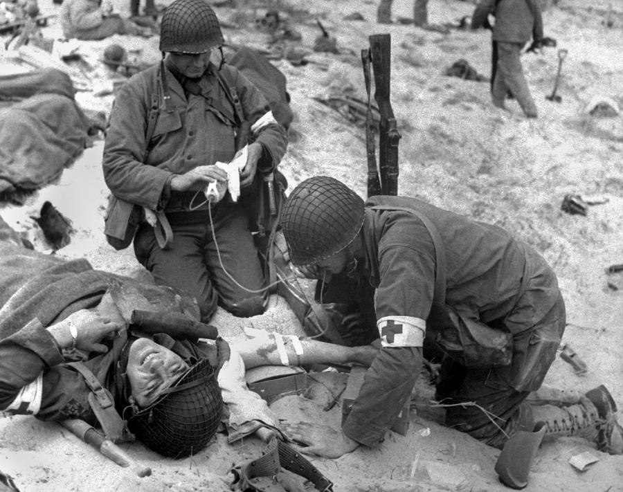Beach Photograph - Medics Treat A Wounded U.s. Soldier #1 by Everett